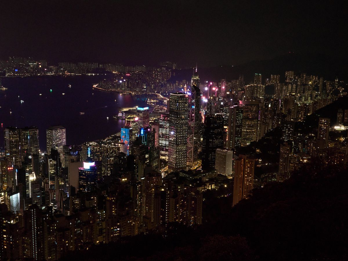 The glittering Hong Kong Island skyline spreads across Victoria Harbour at night, viewed from high atop Victoria Peak.